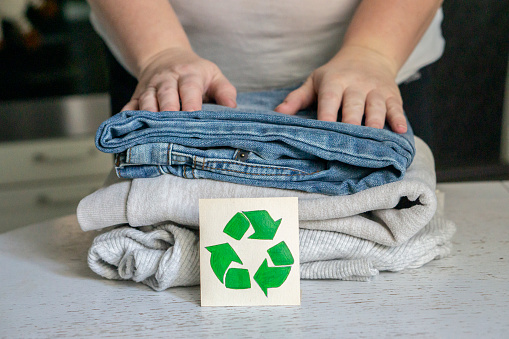 a photo of a garment recycling concept. A stack of clothes is on the