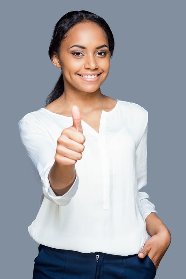 Person smiling, giving thumbs up, wearing a white shirt against a gray background.