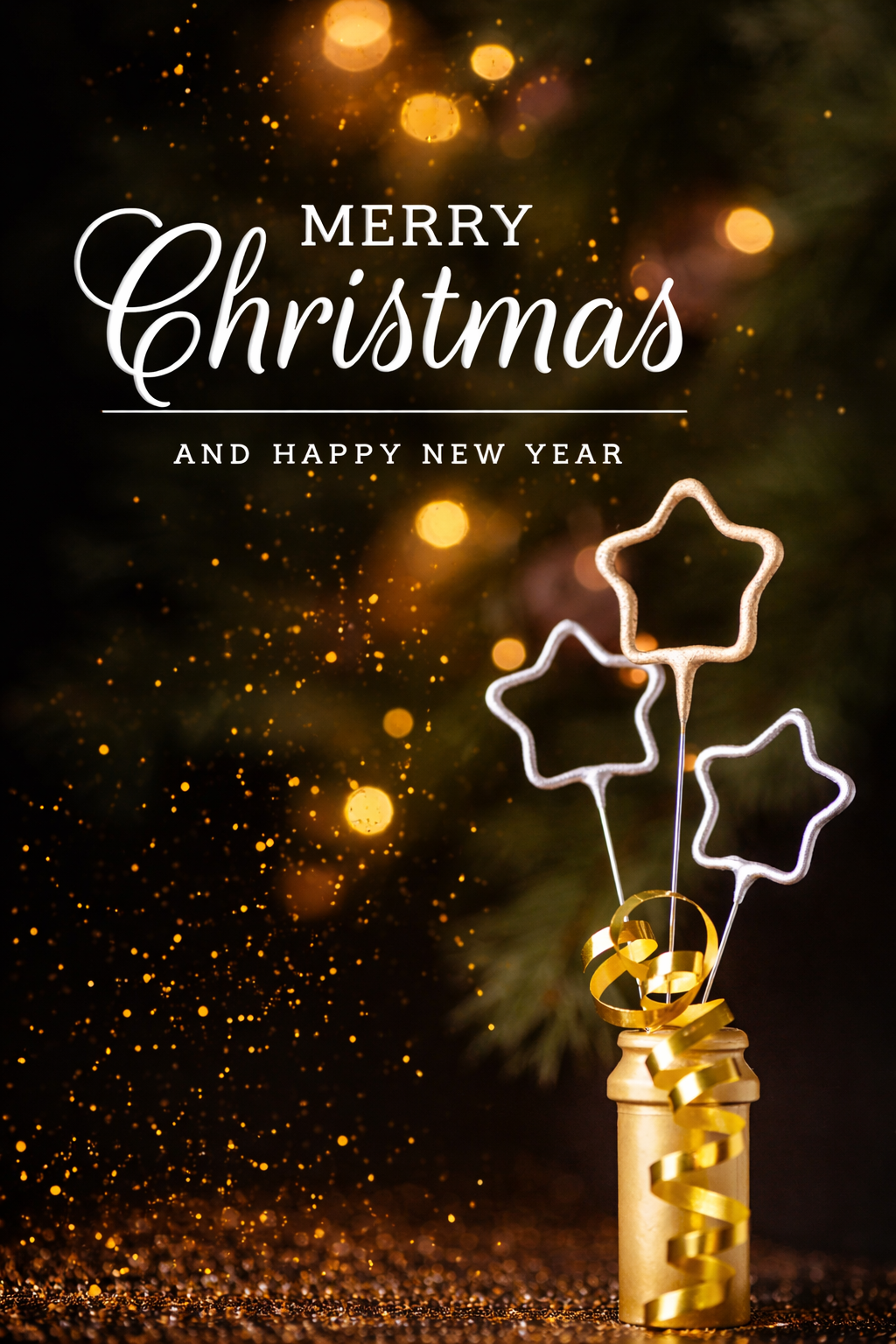 Gold bottle with star-shaped sparklers and ribbon in front of blurred lights and a Christmas tree. Text reads “Merry Christmas and Happy New Year.”.